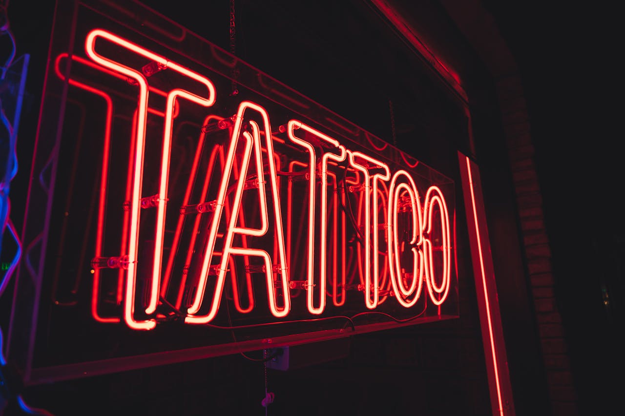 Close-up of a glowing neon tattoo sign, perfect for nightlife and urban themes.